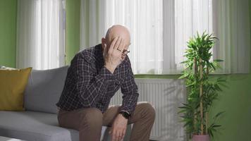 Unhappy old man alone at home bored and sad. Thoughtful old patient sitting alone at home, Sad and depressed bored alone. video