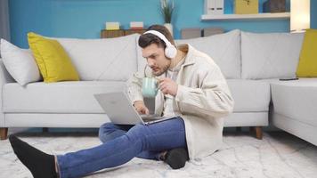 il giovane uomo Guardando film su il computer portatile, guardare a il notizia, parlando per persone è pianto su per gioia a che cosa lui vede su il schermo. video