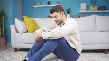 The young man looks around sadly. The man sitting on the ground looks around sadly and alone. video