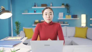 joven asiático mujer mirando a ordenador portátil solo a hogar no satisfecho con el ver ella ve en el pantalla y vueltas a el cámara y batidos su cabeza. video