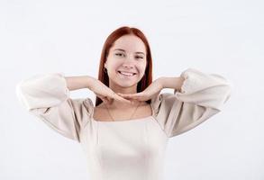 portrait of a young beautiful woman touching her face on white background, copy space photo