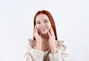 portrait of a young beautiful woman touching her face on white background, copy space photo