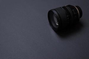 Modern camera lens on black office desk with copy space photo