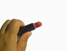 un mano es participación rosado lápiz labial en un blanco antecedentes foto