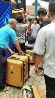 Ciputat Indonesia March 2023 The men were loading their suitcases into the bus during the release ceremony for the Umrah pilgrims to the holy land of Mecca. photo