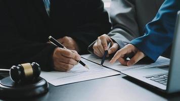 zaken en advocaten bespreken contractpapieren met koperen schaal op bureau in kantoor. wet, juridische diensten, advies, rechtvaardigheid en wet concept foto met film grain effect video