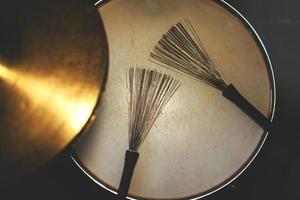 Drumsticks brushes resting on the snare drum photo