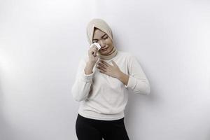 An unhappy Asian Muslim woman wearing a headscarf is wiping her tears in despair, feeling depressed and lonely. photo