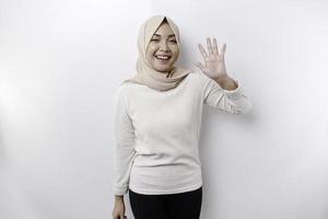 retrato de un joven hermosa asiático musulmán mujer vistiendo un Pañuelo gesticulando eid Mubarak saludo foto