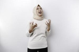 A portrait of an Asian Muslim woman wearing a headscarf isolated by white background looks depressed photo