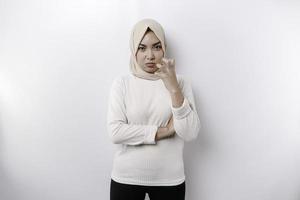 A portrait of an Asian Muslim woman wearing a headscarf isolated by white background looks depressed photo