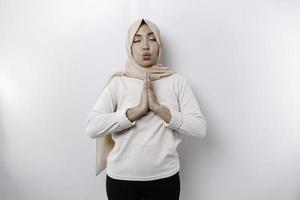 Asian Muslim woman practicing yoga and meditates pose with closed eyes isolated by white background photo
