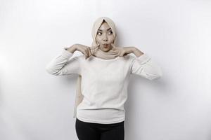 A portrait of a cute Asian Muslim woman wearing a headscarf, and feeling excited and isolated by a white background photo