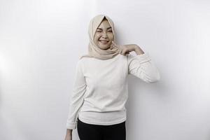 A portrait of a cute Asian Muslim woman wearing a headscarf, and feeling excited and isolated by a white background photo