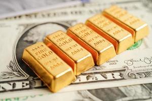 Gold bars on US dollar banknote money, finance trading investment business currency concept. photo