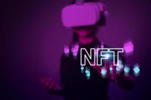 Women with virtual reality VR goggle finger touch virtual screen, NFT token digital crypto art blockchain technology concept photo