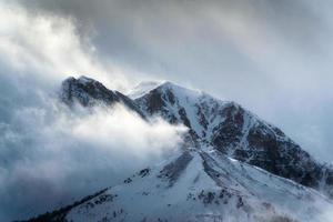 Nevado cumbre rocoso montañas con luz de sol brillante en desierto a nacional parque foto