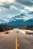 la carretera viaje en autopista Entre pino bosque conducción Derecho a rocoso montañas en Campos de hielo avenida foto