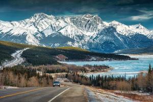 Scenery of Road trip on highway with rocky mountains and frozen lake at Icefields Parkway photo