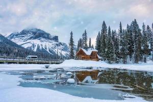 Emerald Lake with wooden lodge glowing and snowfall in pine forest on winter at Yoho national park photo