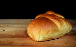 a closeup single shot of delicious homemade bread with flour on a black background with blurred shadow images. photo