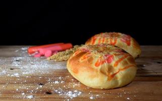 a closeup shot of delicious homemade bread with flour on a black background with blurred shadow images. photo