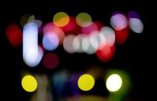 Bright multi-colored bokeh spots on a dark background. photo
