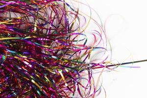 Festive background. Lots of multicolored tinsel close-up on a white background. photo