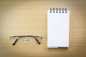 Eyeglasses and Notepad with blank page photo