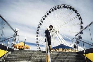 March 8 2023. Chicago, Illinois. A women poses near a Ferris Wheel at Navy Pier in Chicago. photo