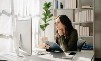 confidente negocio experto atractivo sonriente joven mujer mecanografía ordenador portátil ang participación digital tableta en escritorio en creativo hogar oficina.