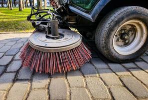 Close-up sweeper machine cleaning. Concept clean streets from debris. photo