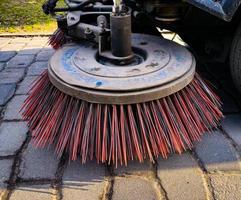 Close-up sweeper machine cleaning. Concept clean streets from debris. photo