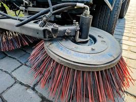 Close-up sweeper machine cleaning. Concept clean streets from debris. photo