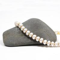 Pendant necklace bracelet of precious pearls on a white background photo