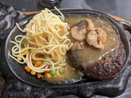 Extra beef steak with noodles and mushroom sauce. The photo is suitable to use for food background, poster and food content media.