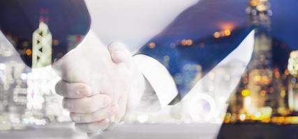 Two business men shaking hand on blurry background photo