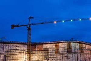 construcción sitio con grúas en crepúsculo hora foto