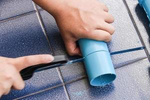 Plumber sawing a pvc pipe photo