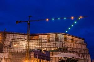 construcción sitio con grúas en crepúsculo hora foto