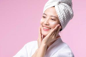 Young asian woman applying facial skincare face cream, cosmetic moisturiser on healthy natural skin make up face. Portrait glowing smile girl person model with care beauty product, spa, cosmetology. photo