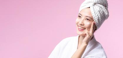 Young asian woman applying facial skincare face cream, cosmetic moisturiser on healthy natural skin make up face. Portrait glowing smile girl person model with care beauty product, spa, cosmetology. photo