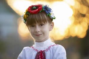 Beautiful little Slavic girl in national clothes on a bokeh background. Ukrainian or Belarusian child. photo