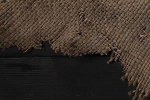 Burlap close-up. Rough canvas. Rough weaving fabric background on a wooden background. photo