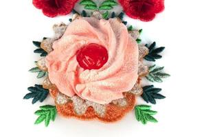 Beautiful cake on a bright floral fabric isolated on a white background. photo