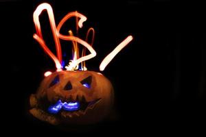 Glowing halloween pumpkin on a black background. photo