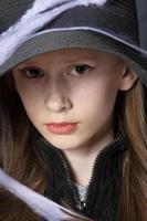 Little girl in a black hat on a halloween spider web. photo