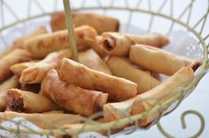 The delicious golden spring rolls serve in a wodden basket photo