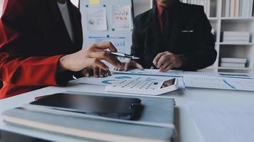 Financial analysts analyze business financial reports on a digital tablet planning investment project during a discussion at a meeting of corporate showing the results of their successful teamwork. video