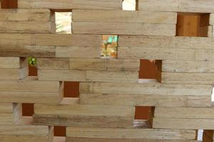 Closed up view of light brown wood wall made from small piece of timber, small square shape hole on broad. photo